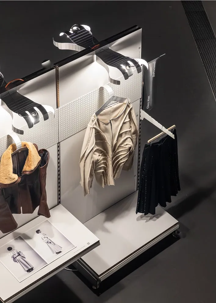 Un couple de bottes et un manteau pendus sur une étagère