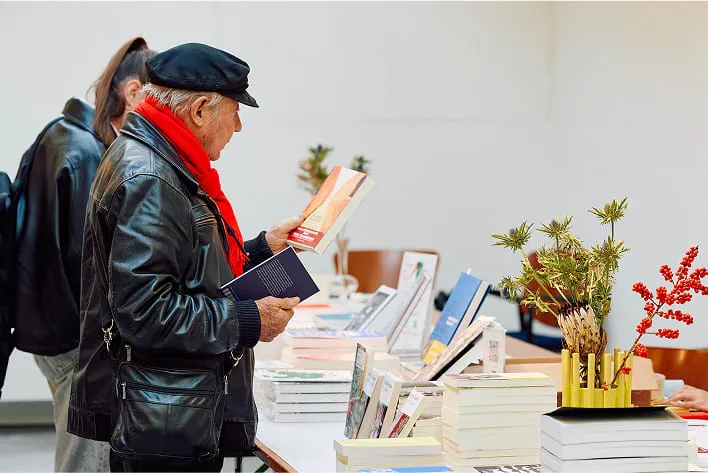 Un homme debout devant une table remplie de livres