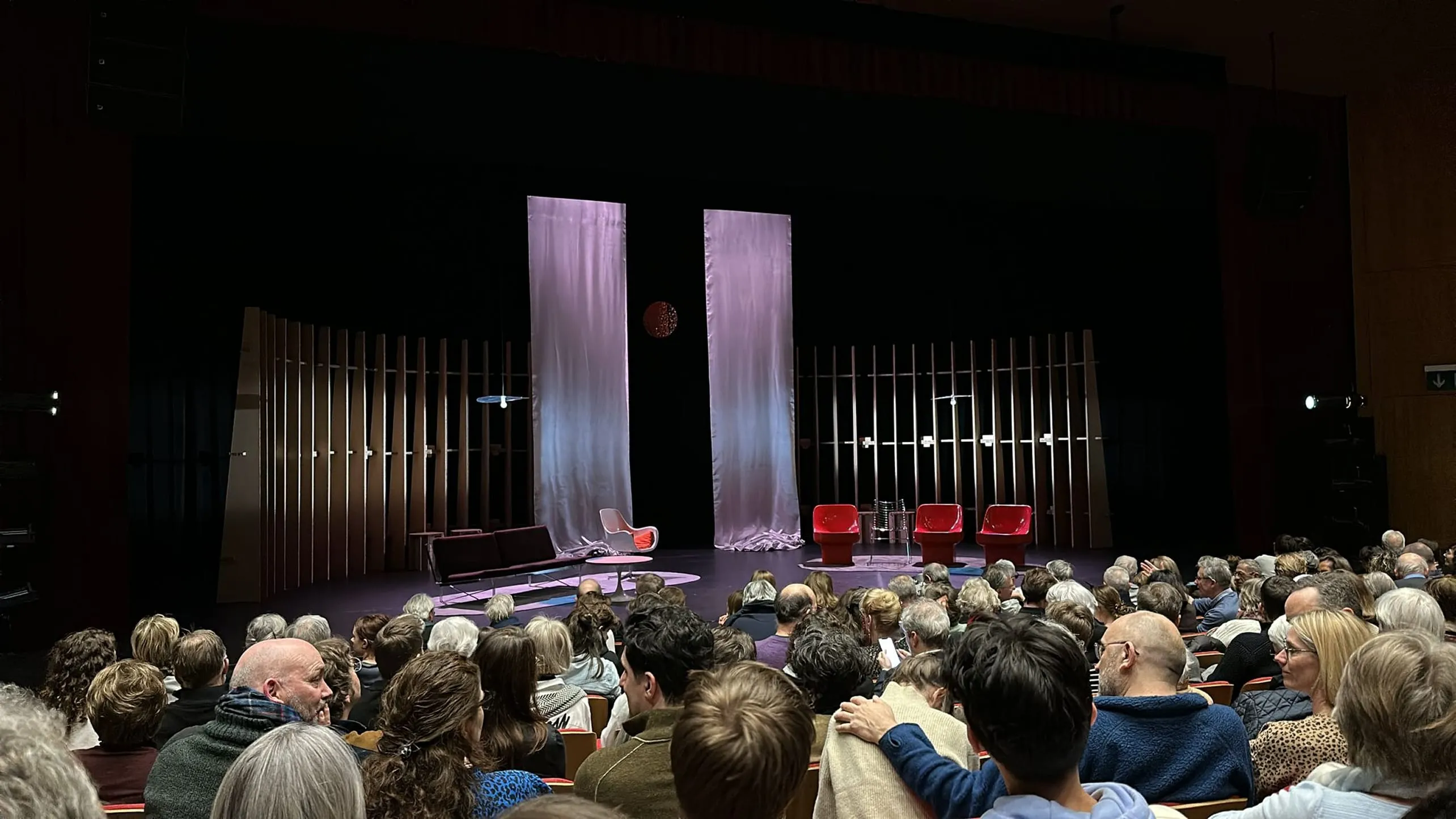 Un groupe de personnes assises devant une scène