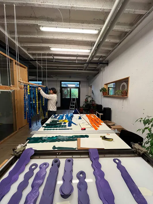 Un homme debout devant une table remplie de ciseaux pourpre