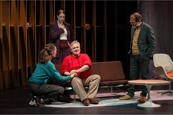 Un groupe de personnes assises autour d'un canapé sur une scène