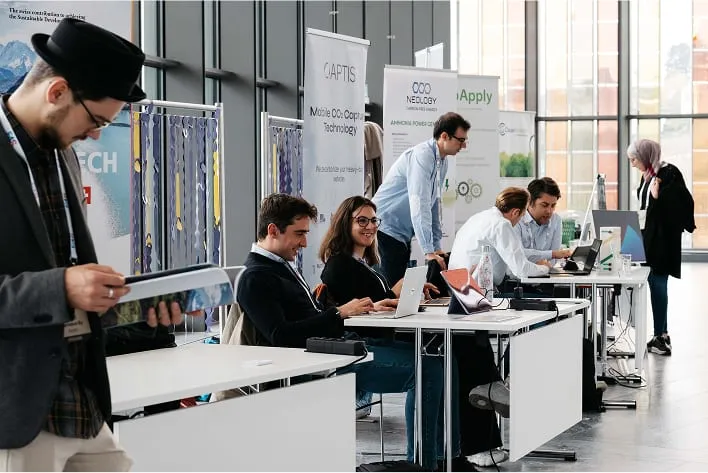 Un groupe de personnes assises à des bureaux dans une pièce