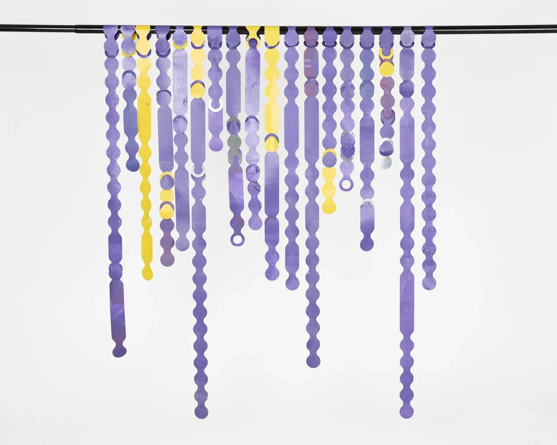 Mur blanc avec des perles de couleur pourpre et jaune pendantes à partir de lui