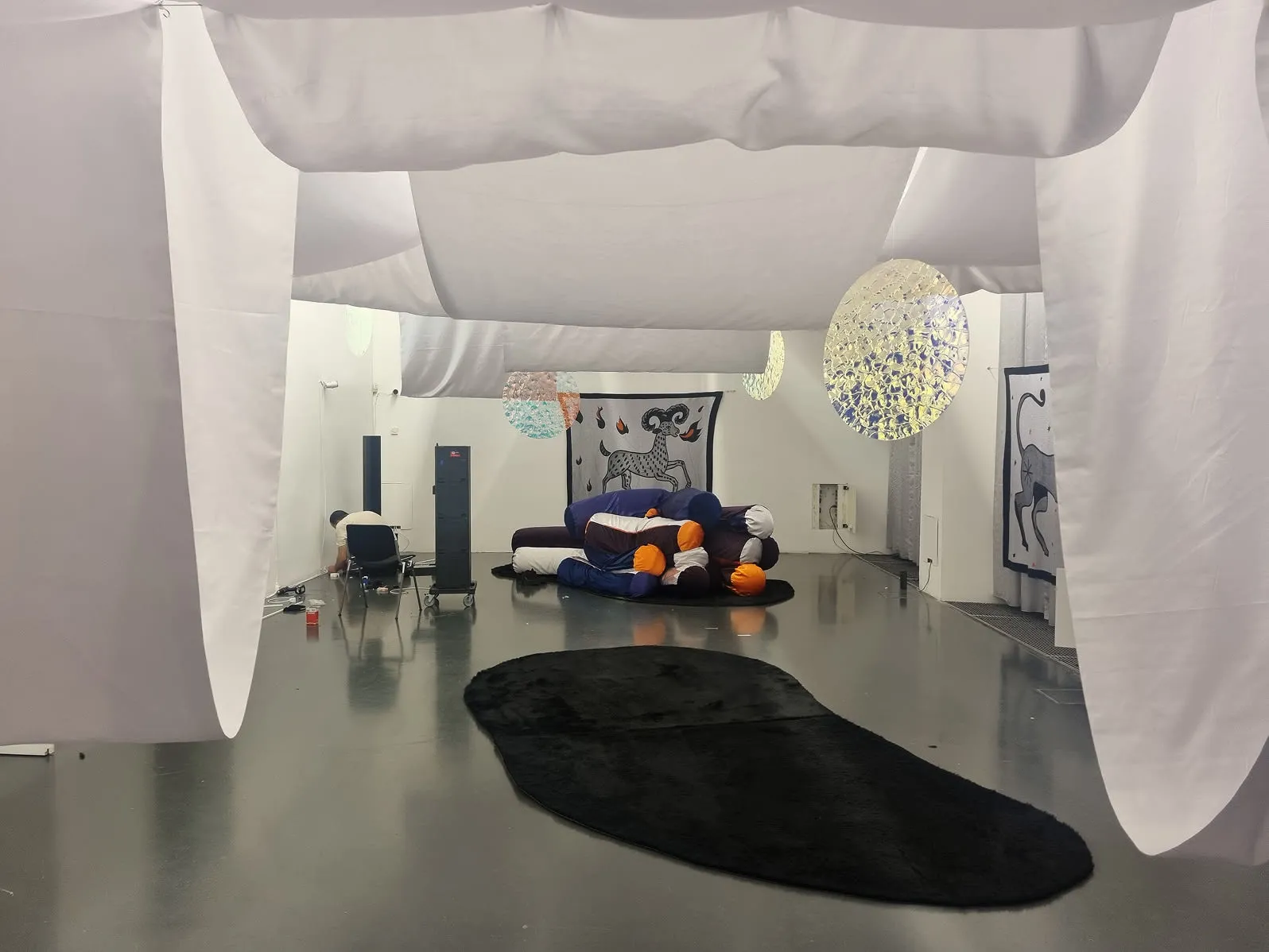 Une salle de séjour avec un canapé et une tapisserie noire