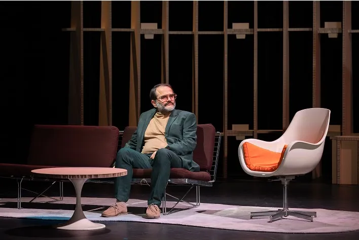 Un homme assis sur une chaise à côté d'une table