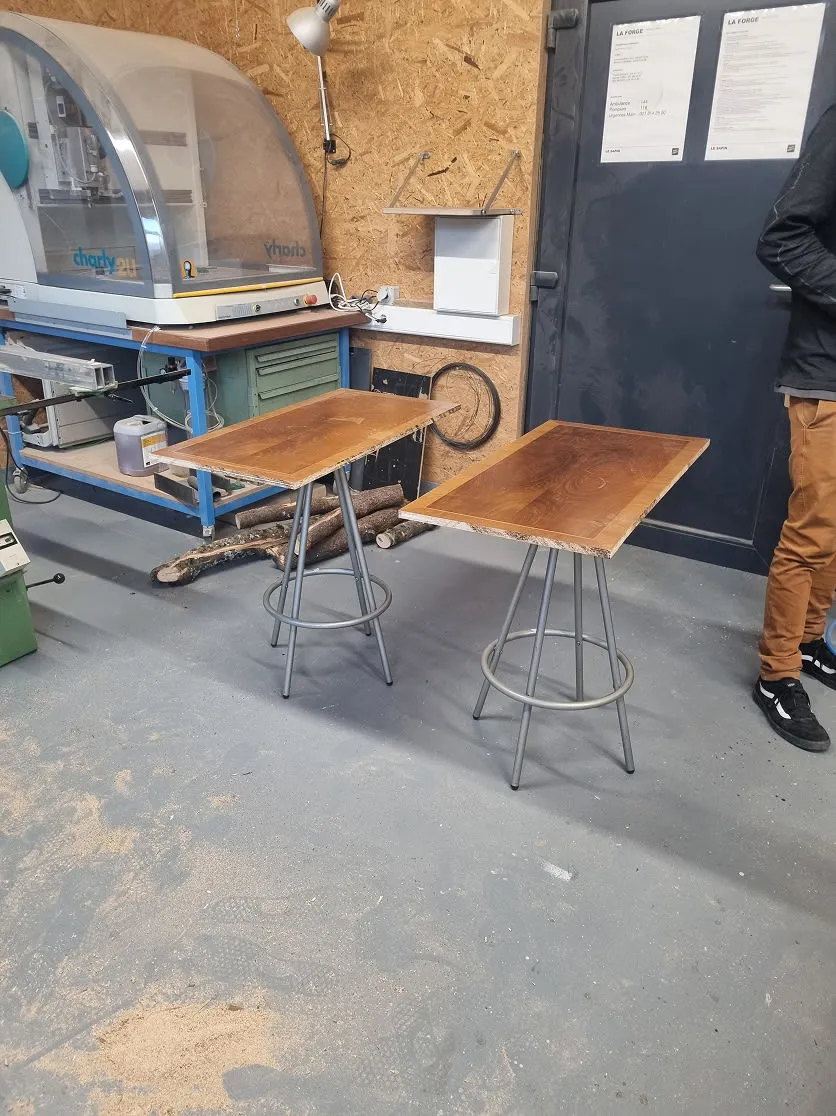 Un homme debout à côté d'une table en bois