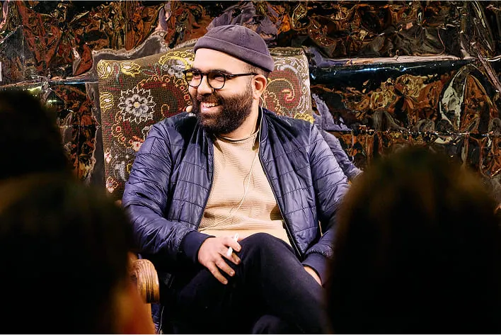 Un homme assis sur une chaise avec barbe
