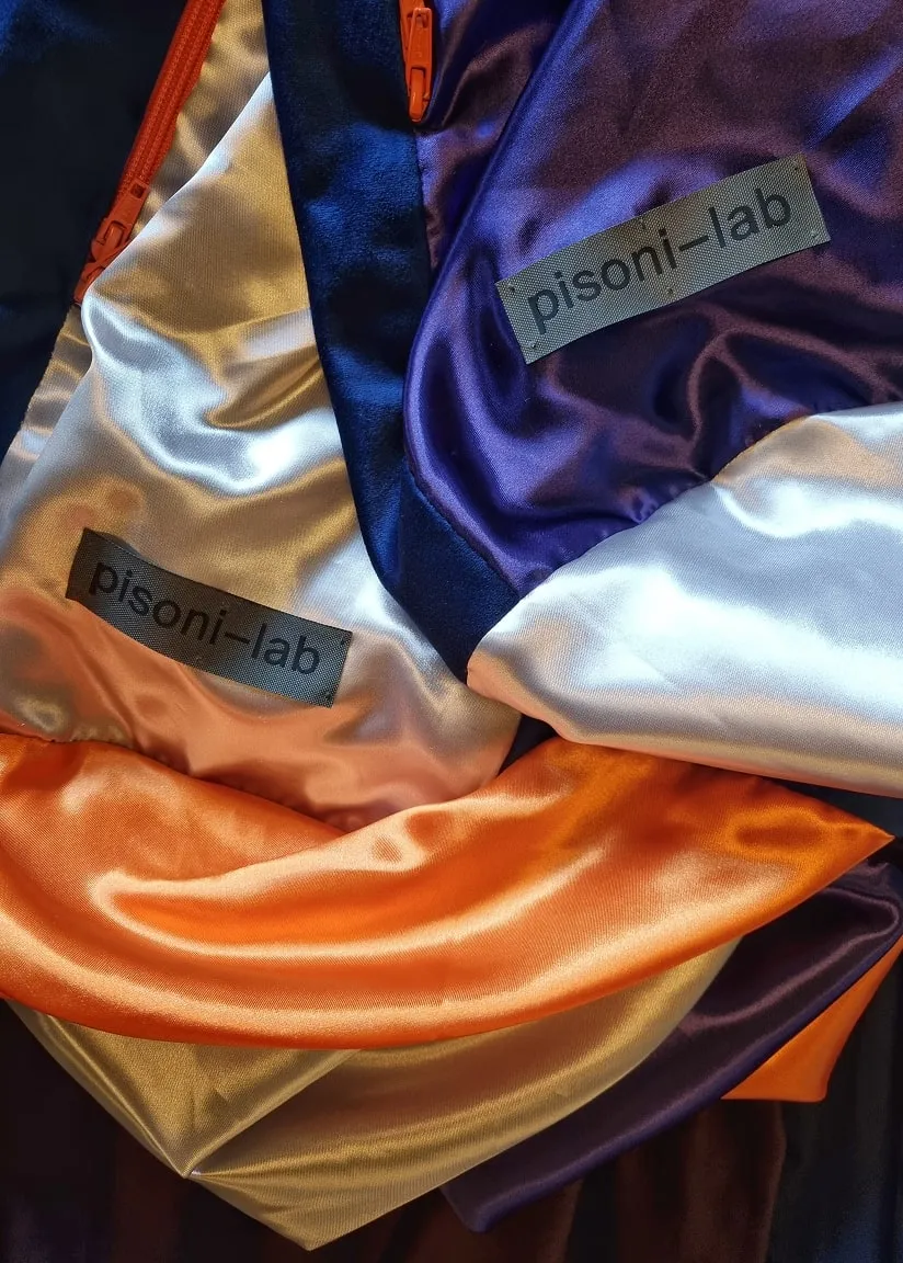 Une pile de vêtements de différentes couleurs avec des étiquettes sur eux